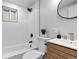 Clean bathroom with white tile, modern vanity, and shower/tub combo at 2610 W 90Th Pl, Denver, CO 80260