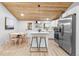 Open concept kitchen with white cabinets, stainless steel appliances, and breakfast bar at 2610 W 90Th Pl, Denver, CO 80260