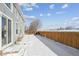 Snowy backyard with a wooden fence and open space at 5928 E Conservation Dr, Frederick, CO 80504