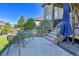 Backyard patio with an umbrella table and chairs adjacent to the back steps and artificial turf at 8259 Arapahoe Peak St, Littleton, CO 80125