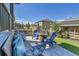 Backyard patio with Adirondack chairs around a stone fire pit, bench seating with decorative pillows and artificial turf at 8259 Arapahoe Peak St, Littleton, CO 80125