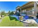 Inviting backyard with a stone patio, seating area, fire pit, and artificial grass at 8259 Arapahoe Peak St, Littleton, CO 80125