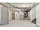 Unfinished basement with concrete flooring, exposed pipes, white walls, and a staircase at 645 Flintwood Pl, Lafayette, CO 80026