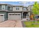 Inviting two-story home with a charming front porch, brick driveway, and attached two-car garage at 645 Flintwood Pl, Lafayette, CO 80026