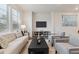 Sunlit living room with plush seating and contemporary decor with large windows at 645 Flintwood Pl, Lafayette, CO 80026