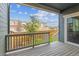 Inviting covered patio with wood-like flooring, offering a view of the fenced backyard and neighboring homes at 645 Flintwood Pl, Lafayette, CO 80026