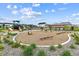 Community playground with modern play structures, swings and a soft gravel surface surrounded by landscaping at 645 Flintwood Pl, Lafayette, CO 80026