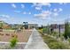 Modern community playground with swings, slides and mature landscaping on the outer perimeter at 645 Flintwood Pl, Lafayette, CO 80026