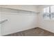A walk-in closet with carpet, a window with blinds, and a shelf with a clothes rod to hang clothes at 645 Flintwood Pl, Lafayette, CO 80026