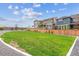 Spacious grassy yard with well-kept green grass, modern landscaping, a wooden fence and neighboring homes at 645 Flintwood Pl, Lafayette, CO 80026