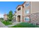 Attractive condo building with stone accents, well-maintained landscaping, and a clear blue sky at 9518 W San Juan Cir # 307, Littleton, CO 80128