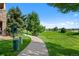 Scenic community pathway with lush greenery, tall trees, and open lawn, ideal for relaxing strolls at 9518 W San Juan Cir # 307, Littleton, CO 80128
