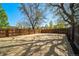 A large, fenced backyard with mature trees offering plenty of space for outdoor activities at 7275 E 8Th Ave, Denver, CO 80220