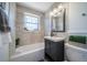 Updated bathroom features tub and shower with subway tile and modern vanity at 7275 E 8Th Ave, Denver, CO 80220