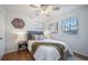 Bright bedroom features hardwood floors, modern ceiling fan, neutral decor, and large window at 7275 E 8Th Ave, Denver, CO 80220