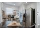 Modern kitchen with stainless steel appliances and view to white door at 7275 E 8Th Ave, Denver, CO 80220
