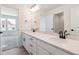 Bright bathroom featuring a double vanity with white cabinets and stone countertop, with an adjoining room at 8386 Cokedale Cir, Littleton, CO 80125