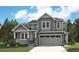 Two-story home featuring stone accents, a covered front porch, and an attached two-car garage at 8386 Cokedale Cir, Littleton, CO 80125