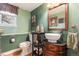 Unique bathroom with green walls, decorative vanity, and vintage accents create a charming and cozy atmosphere at 4217 S Jericho St, Aurora, CO 80013