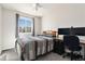 Comfortable bedroom featuring a quilt-covered bed, a large window, and a modern desk for focused work at 4217 S Jericho St, Aurora, CO 80013