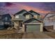 Charming two-story home with a well-manicured lawn and attached two-car garage as the sun sets at 4217 S Jericho St, Aurora, CO 80013