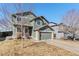 Inviting two-story home with a two-car garage, complemented by the lush green grass and shade trees at 4217 S Jericho St, Aurora, CO 80013
