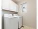 Bright laundry room with white cabinets and modern appliances for efficient laundry tasks at 4217 S Jericho St, Aurora, CO 80013