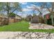 Grassy backyard with a shed, a chainlink fence, and mature trees on a sunny day at 4353 Sherman St, Denver, CO 80216