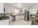 Bright white kitchen featuring stainless steel appliances, modern finishes, and tile flooring at 4353 Sherman St, Denver, CO 80216