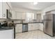 Bright kitchen with white cabinets, stainless steel appliances, and tile flooring at 4353 Sherman St, Denver, CO 80216