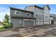 Contemporary three-story townhouse with attached garages and gray siding at 397 East St, Louisville, CO 80027