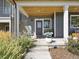 Inviting front porch with wood ceiling, white pillars, and lush landscaping enhancing curb appeal at 397 East St, Louisville, CO 80027