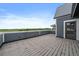 Large outdoor deck with gray planking offers scenic views with blue siding on the adjacent modern home at 397 East St, Louisville, CO 80027