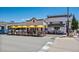 Charming storefronts with inviting outdoor seating under colorful umbrellas on a sunny day at 397 East St, Louisville, CO 80027