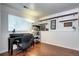 Basement office space with wood floors, natural light, and open shelving storage at 4833 S Pitkin Ct, Aurora, CO 80015