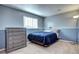 Cozy bedroom featuring a dark blue duvet, dresser, and neutral carpet at 4833 S Pitkin Ct, Aurora, CO 80015