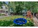 Lush backyard with a trampoline, swing set, and shade trees, creating a fun outdoor play area at 16352 E 104Th Way, Commerce City, CO 80022