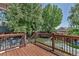 Wooden deck overlooking a spacious backyard with mature trees, a lawn, and play equipment at 16352 E 104Th Way, Commerce City, CO 80022