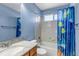 Cozy blue bathroom with a shower and tub, a sink with a granite countertop, and a toilet at 16352 E 104Th Way, Commerce City, CO 80022
