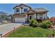 Beautiful two-story home featuring a manicured lawn, stone accents, and a welcoming front porch at 16352 E 104Th Way, Commerce City, CO 80022