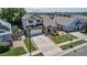 Aerial view of a two-story home with a well-manicured lawn, long drive, and inviting front porch at 16352 E 104Th Way, Commerce City, CO 80022