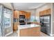 Bright kitchen features stainless steel appliances, granite countertops, and an island at 16352 E 104Th Way, Commerce City, CO 80022