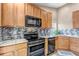 Modern kitchen showcasing stainless steel appliances, mosaic backsplash, and wood cabinetry at 16352 E 104Th Way, Commerce City, CO 80022