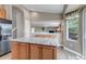 Kitchen with island featuring granite countertop and wood cabinets, with open view to living area at 16352 E 104Th Way, Commerce City, CO 80022