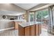 Kitchen island featuring granite countertop and wood cabinets, adjacent to sliding glass door to deck at 16352 E 104Th Way, Commerce City, CO 80022