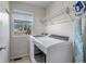Well-lit laundry room with modern washer and dryer, wire shelving, and a window at 16352 E 104Th Way, Commerce City, CO 80022