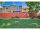 Backyard featuring a lush green lawn, a red fence, and a view of the rear of the home at 7476 E Arkansas Ave # 35-10, Denver, CO 80231