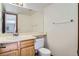 Bathroom featuring a large mirror, toilet, and sink with wood cabinets at 7476 E Arkansas Ave # 35-10, Denver, CO 80231