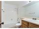 Bright bathroom featuring a shower-over-tub with white tiling and a wooden vanity with a white countertop at 7476 E Arkansas Ave # 35-10, Denver, CO 80231