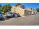 Exterior view of townhouse complex with garage and multiple cars parked in open spaces at 7476 E Arkansas Ave # 35-10, Denver, CO 80231